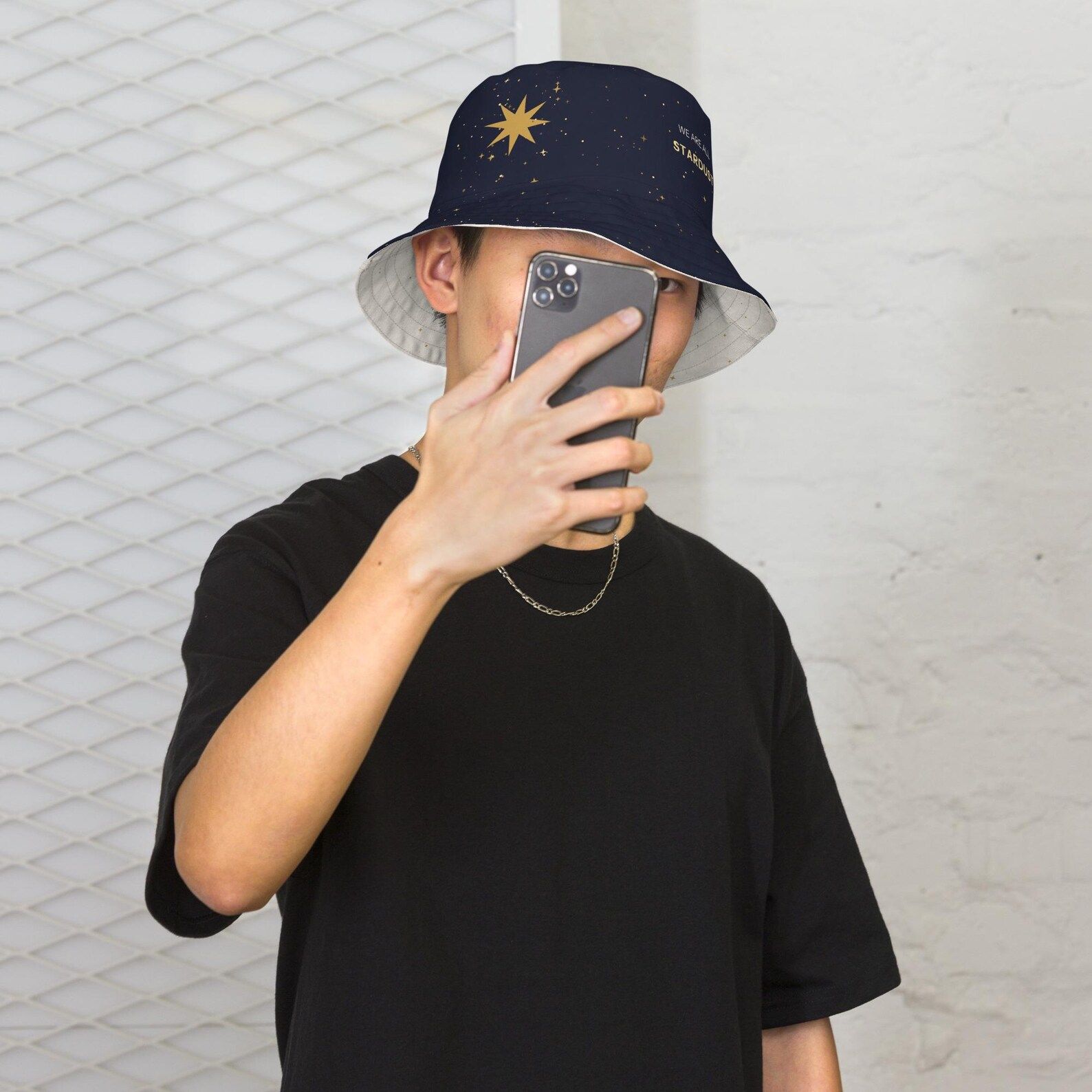 Model smiling in the reversible bucket hat with the dark star-field side up and star