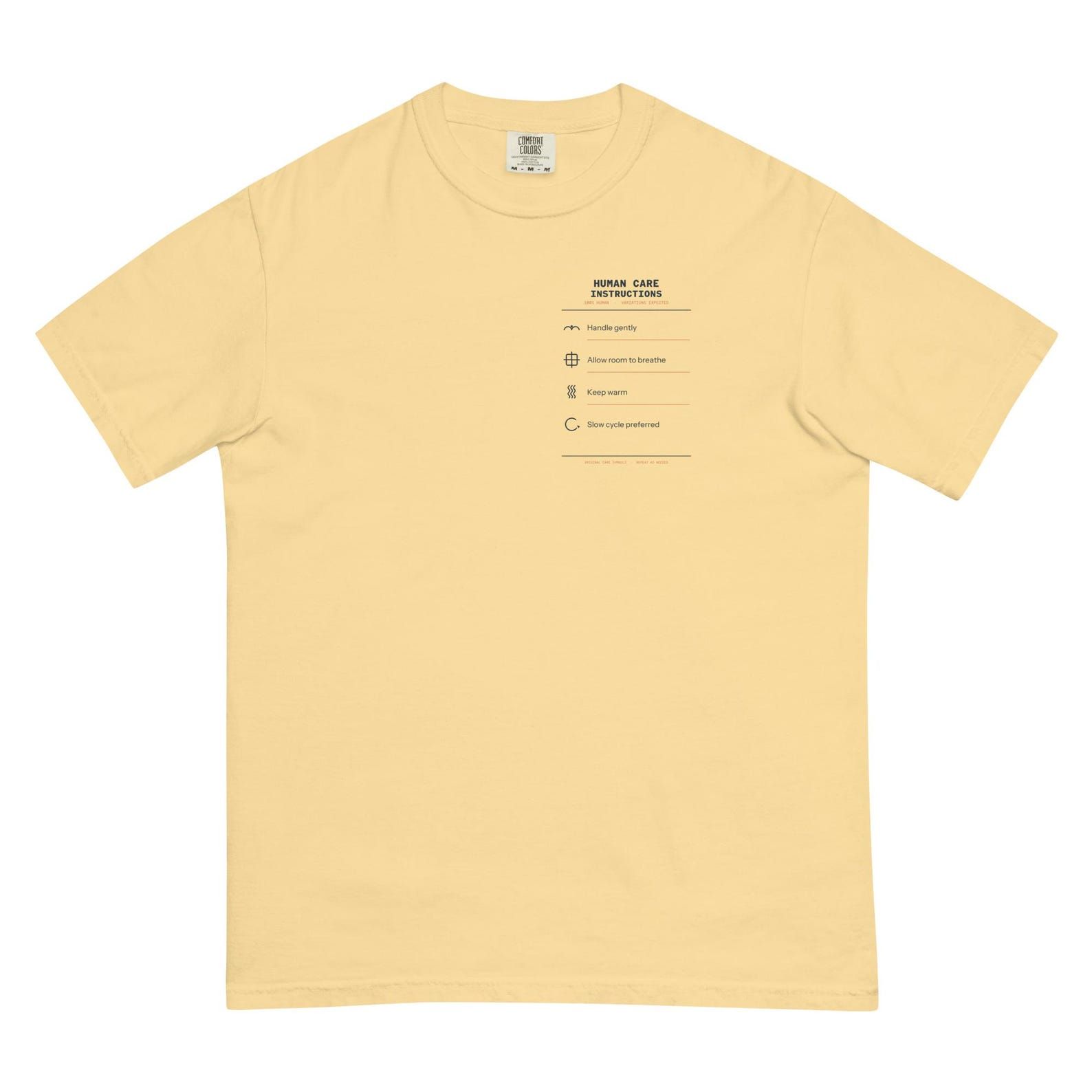 Pale yellow Human Care Instructions T-shirt laid flat with the four-part left-chest design visible