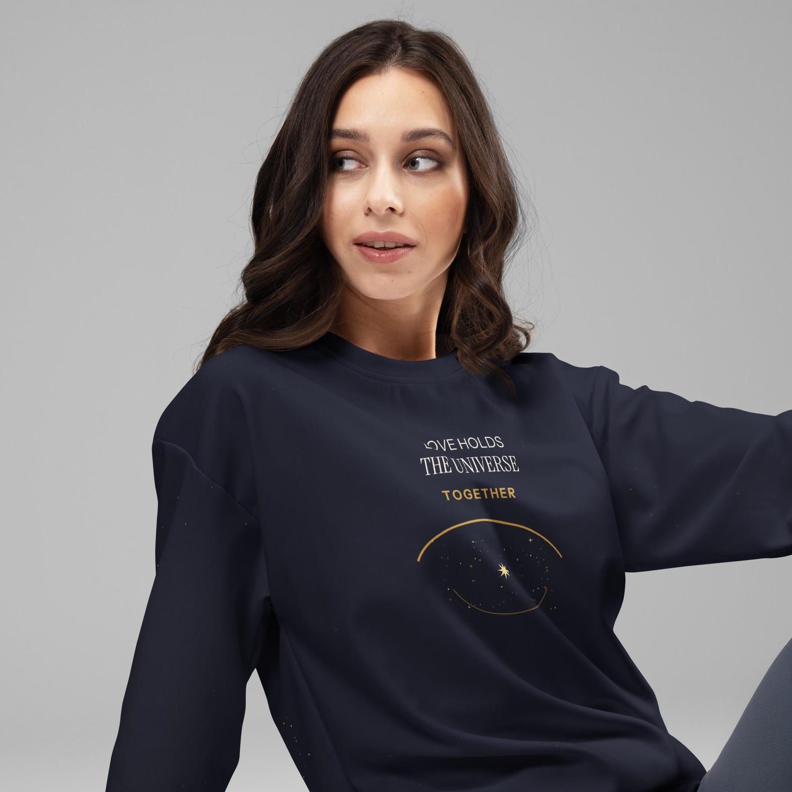 Model wearing the Love Holds the Universe Together sweatshirt with the front statement and celestial design visible