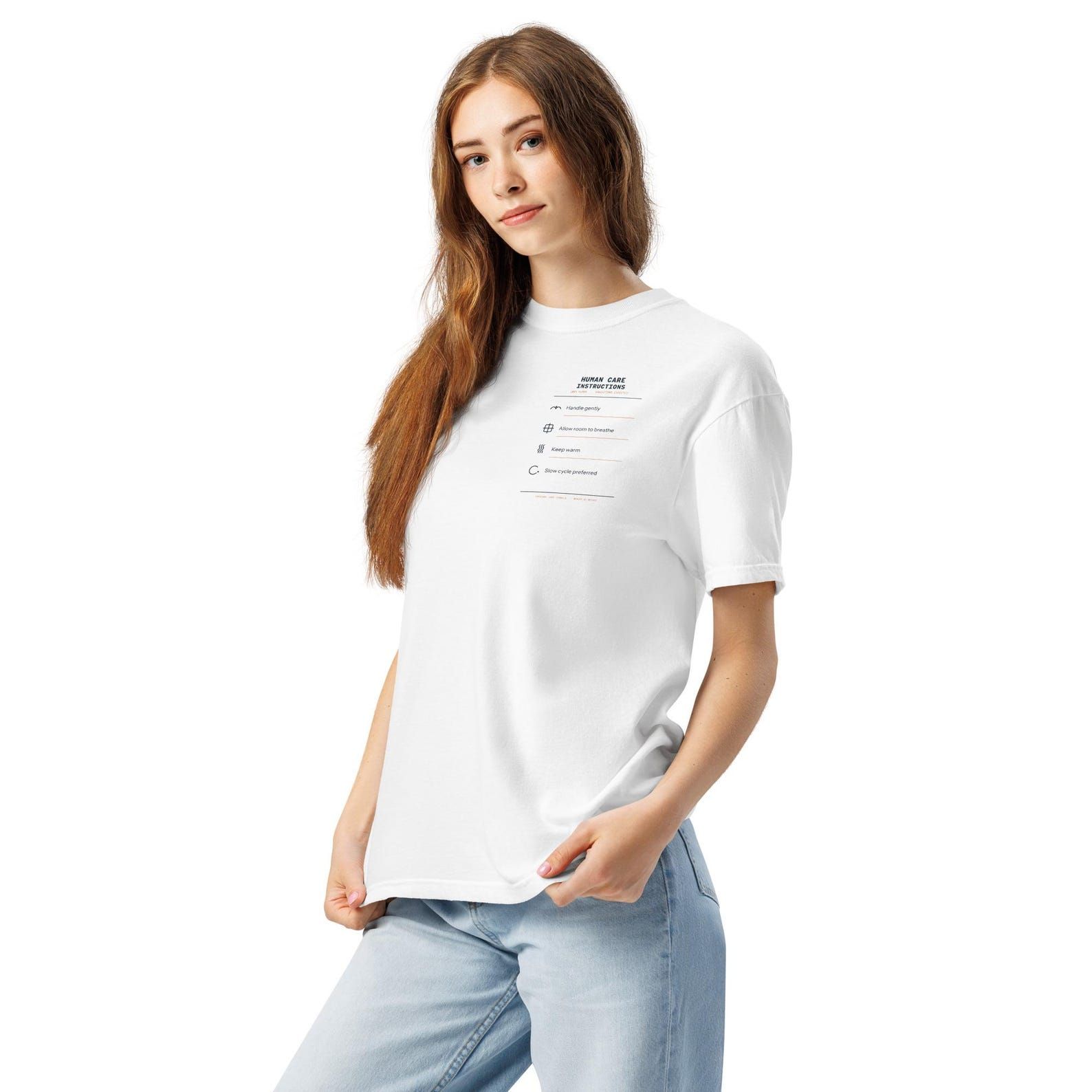 Model wearing a white Human Care Instructions T-shirt with a small care-label design over the left chest