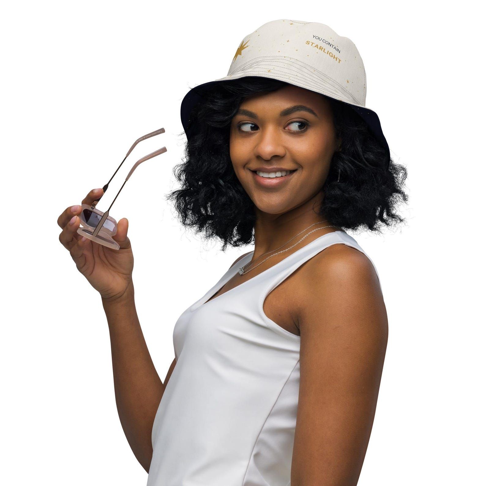 Model wearing the light side of the reversible Stardust Starlight bucket hat with You Contain Starlight on the crown